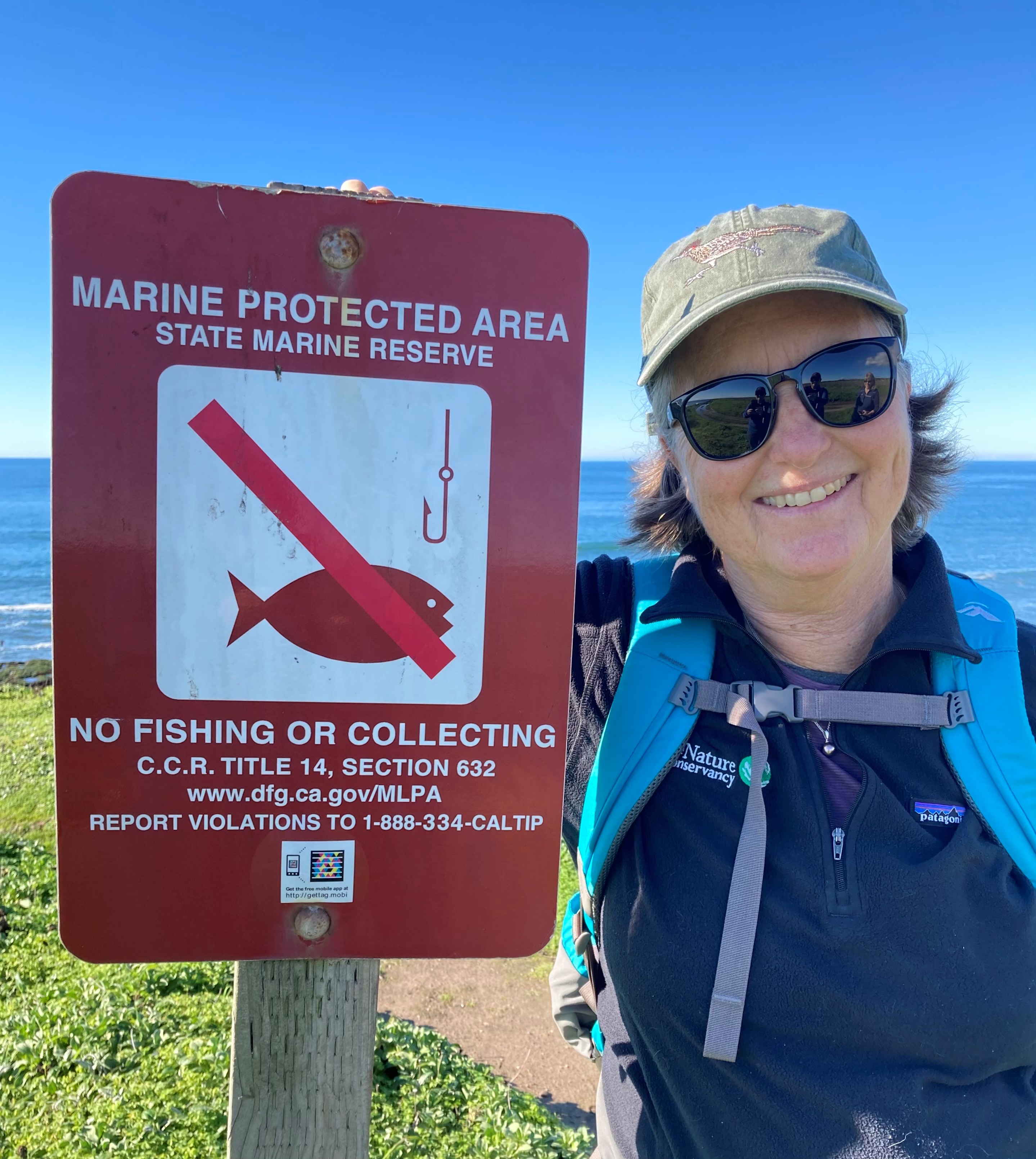 Mary Gleason next to a Marine Protected Area sign.